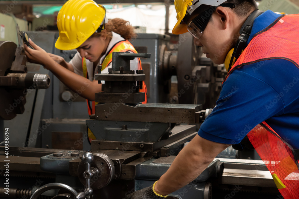 Group of skillful workers using machine equipment in factory workshop . Industry and engineering peo