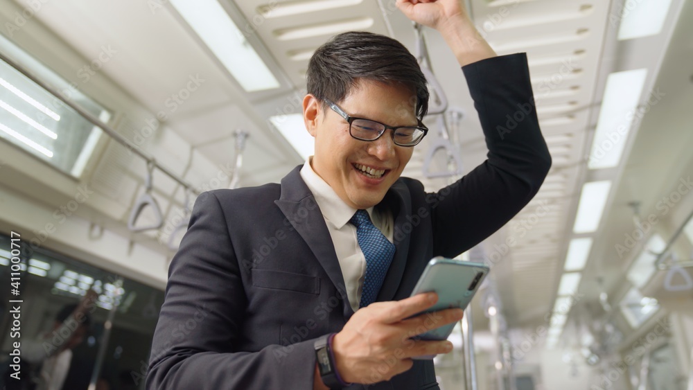 Businessman using mobile phone on public train . Urban city lifestyle commuting concept .