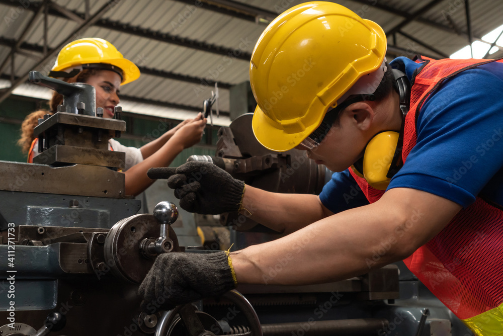 Group of skillful workers using machine equipment in factory workshop . Industry and engineering peo