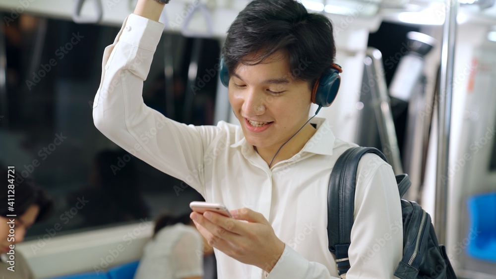 Businessman using mobile phone on public train . Urban city lifestyle commuting concept .