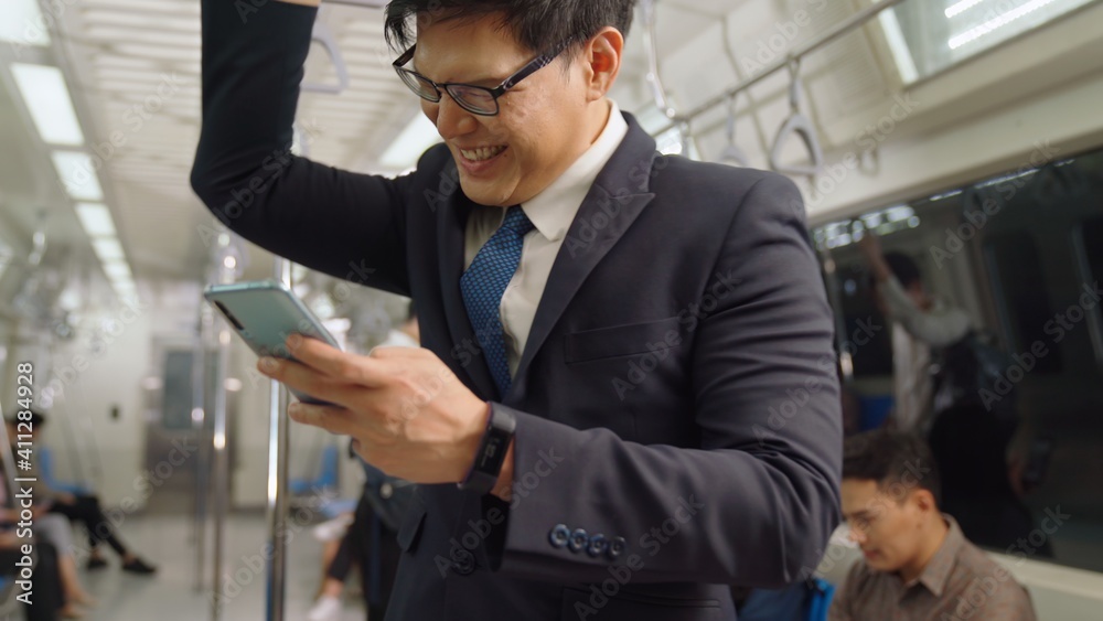 Businessman using mobile phone on public train . Urban city lifestyle commuting concept .