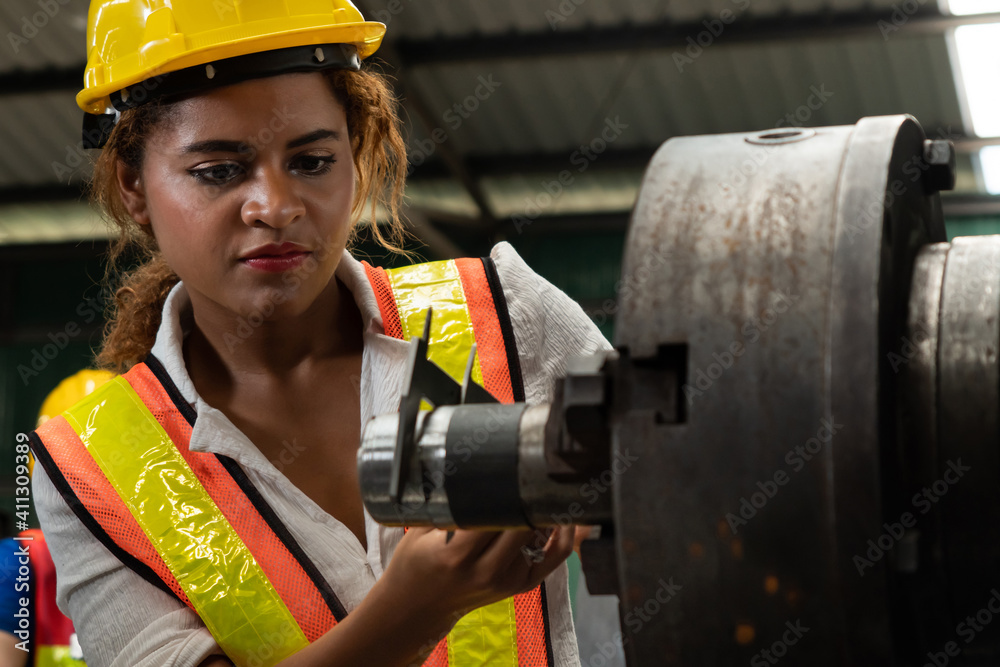 Skillful factory woman worker do machine job in manufacturing workshop . Industrial people and manuf