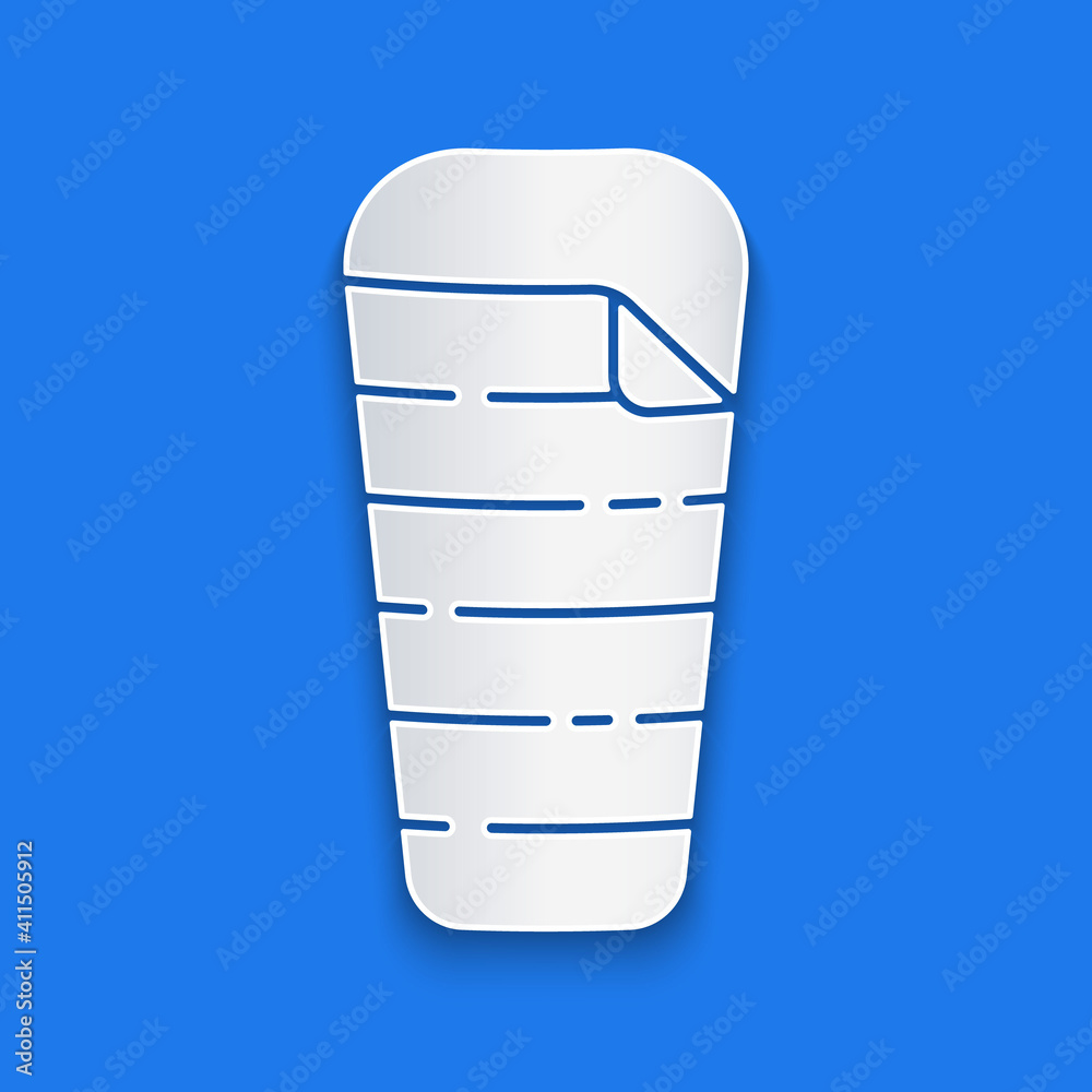 Paper cut Sleeping bag icon isolated on blue background. Paper art style. Vector.