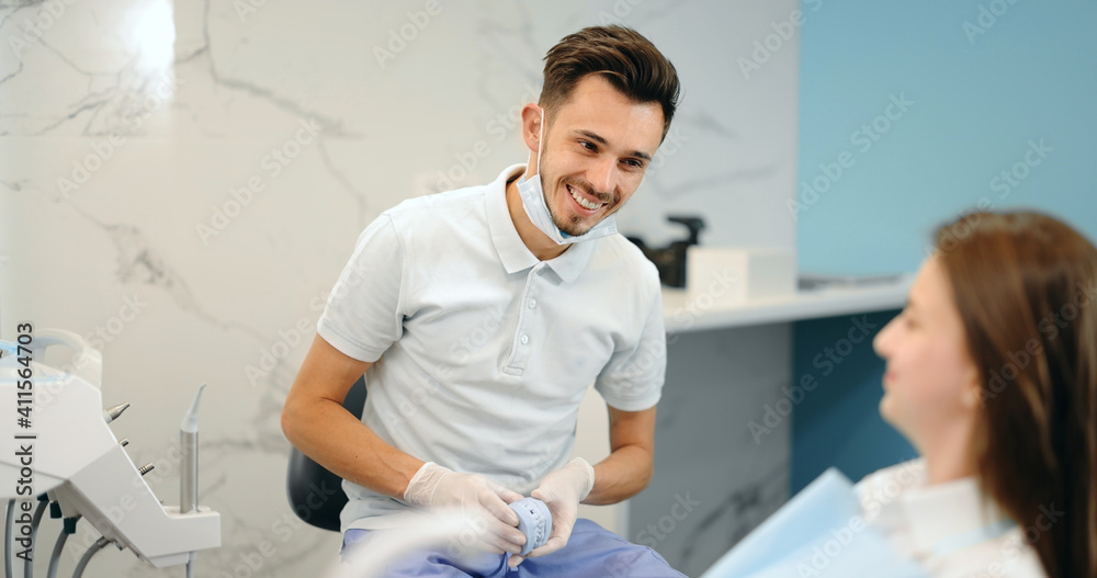 Dentist showing a jaw model, explaining to the young patient the process of orthodontic treatment. G