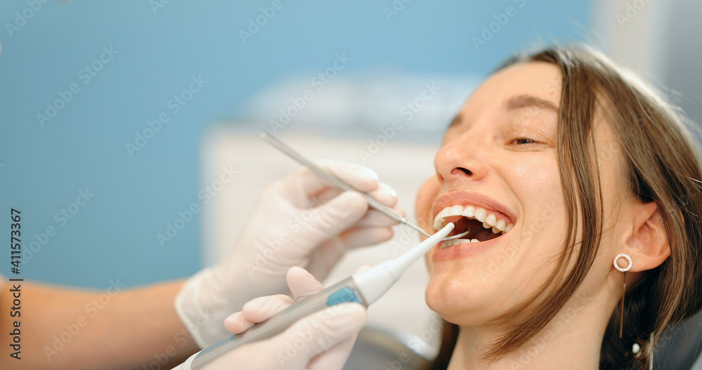 Young patient during a dental checkup. Dentist examining teeth of a woman at the dental office. 4k v