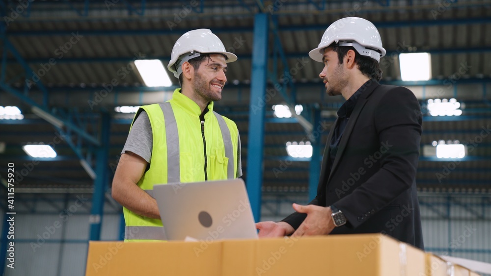 Two factory workers working and discussing manufacturing plan in the factory . Industry and engineer