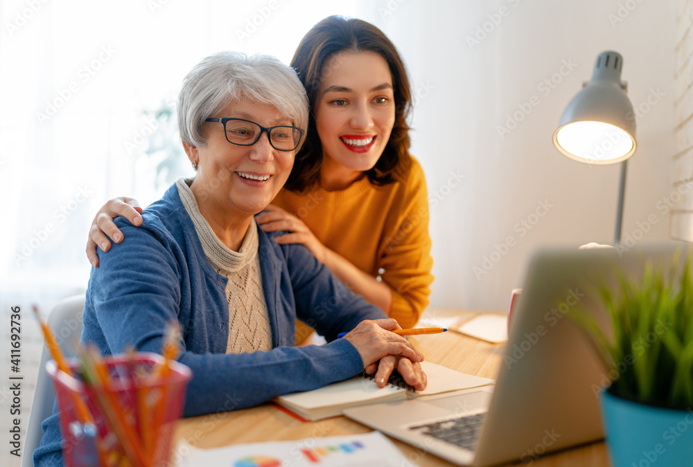 Young and senior women are using laptop