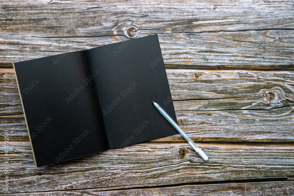 Blank black book and white pen on wooden table background, Black book on wooden table, Top view, cop