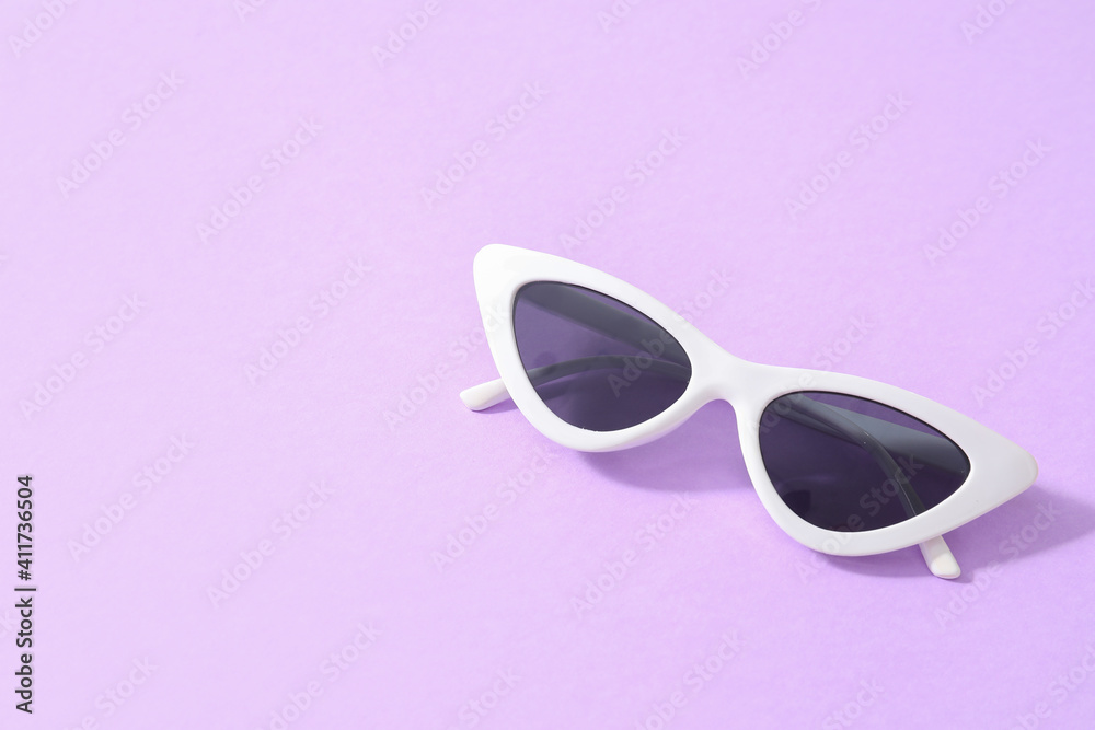 Stylish sunglasses on color background