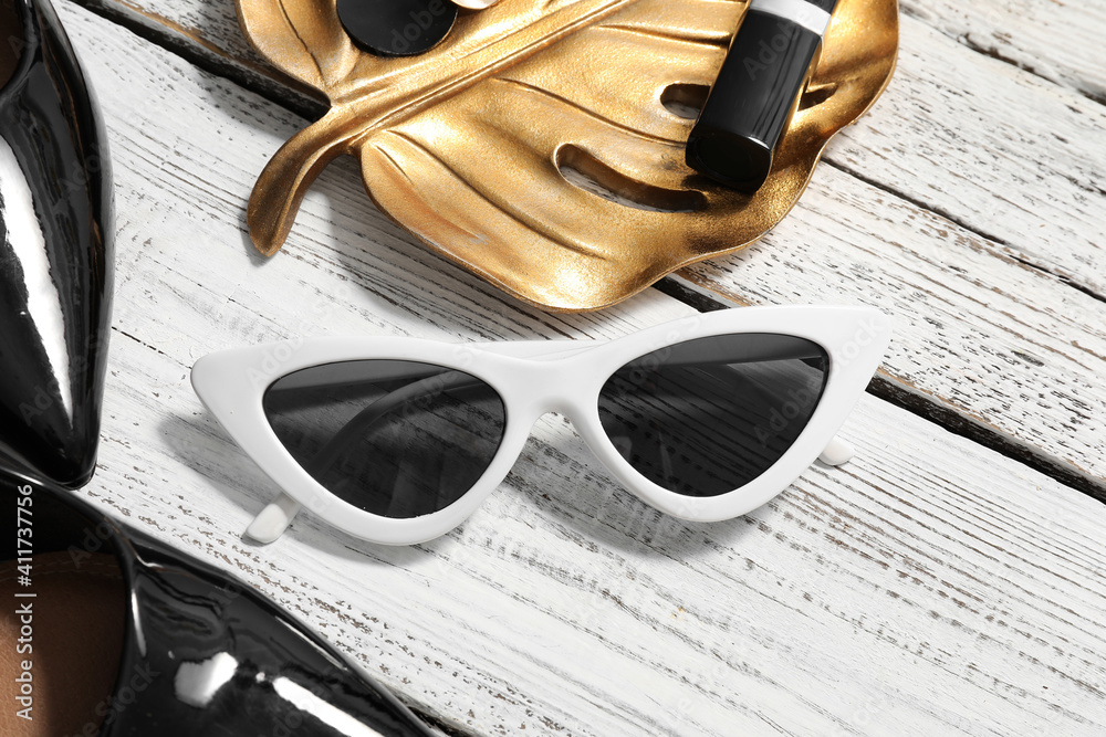 Set of female accessories and sunglasses on wooden background