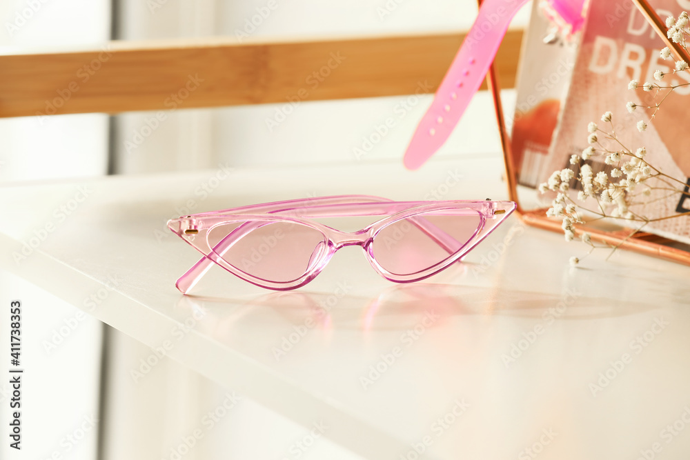 Stylish female sunglasses on table