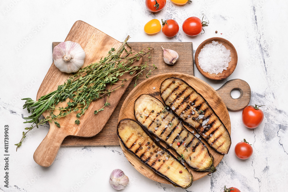 Tasty grilled eggplant with spices and vegetables on white background