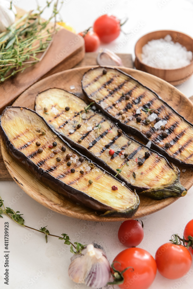 Plate with tasty grilled eggplant on table