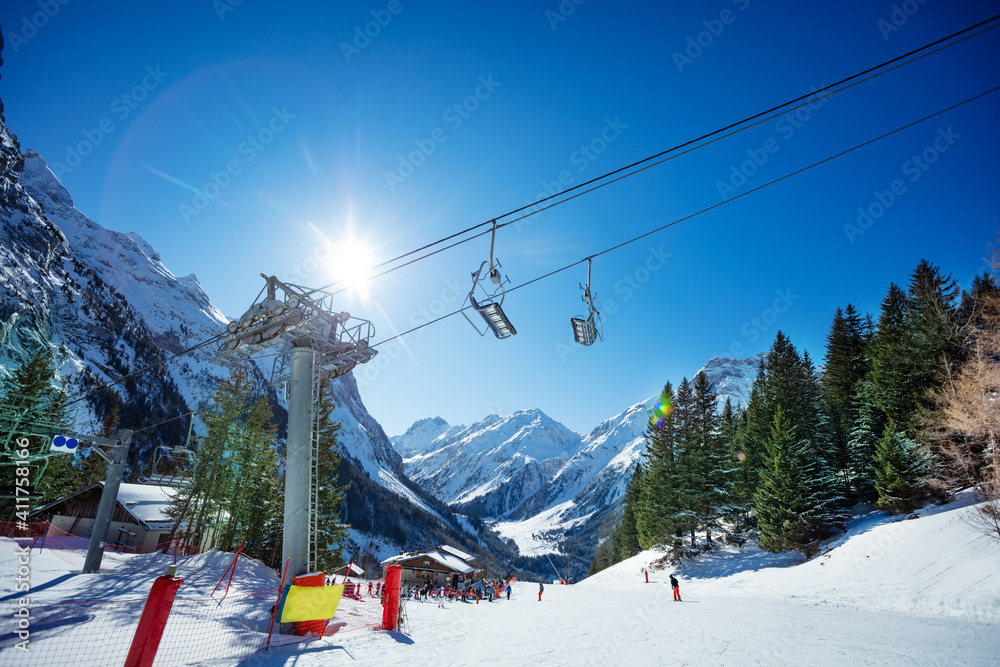 阳光明媚的日子里，在法国阿尔卑斯山的阳光下，滑雪道上有滑雪缆车和椅子