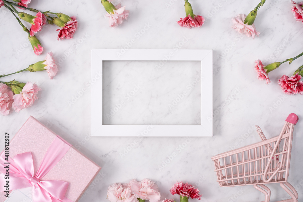 Concept of Mothers day holiday greeting with carnation bouquet on white marble background