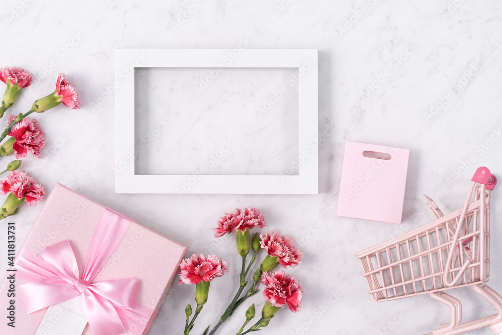 Concept of Mothers day holiday greeting with carnation bouquet on white marble background