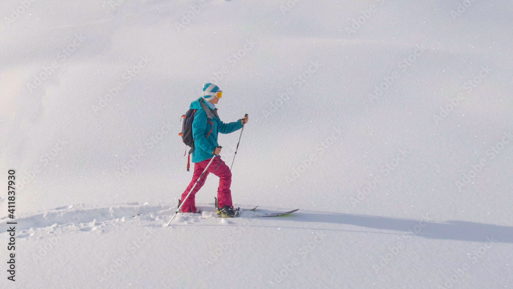 空中飞航：一名年轻女子在乡村徒步旅行，在朱利安阿尔卑斯山滑雪道上滑雪