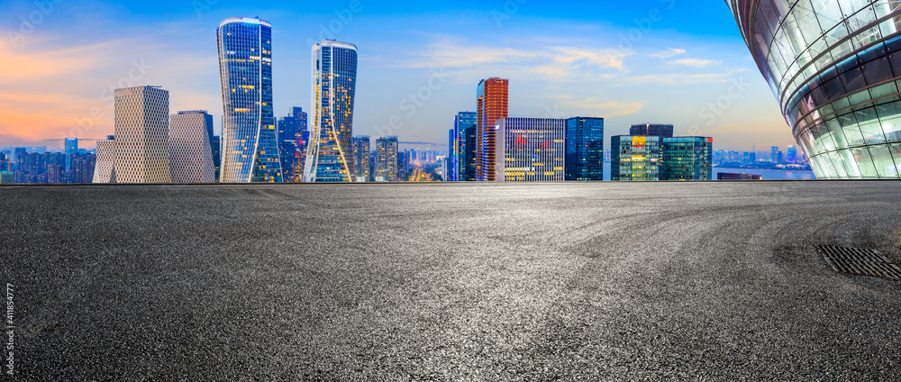 Race track road and modern city skyline with buildings in Hangzhou at night.