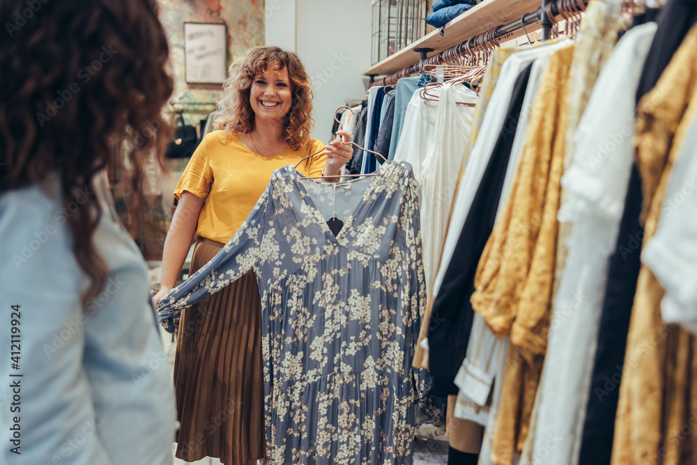 Clothing store owner helping a customer