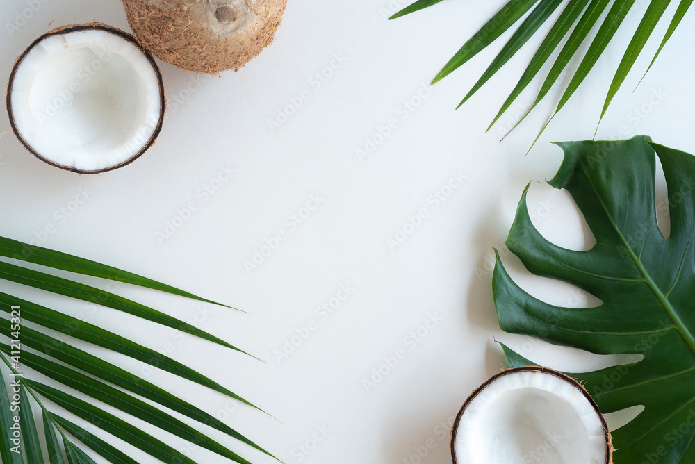 Tropical green palm leaf and cracked coconut on white background. Nature concept. flat lay, top view