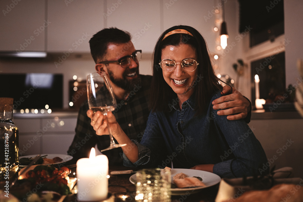 Young woman laughing during a fun dinner party with friends