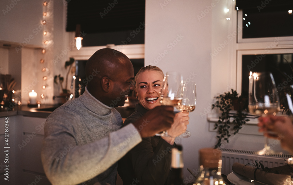 Laughing couple making a toast during a dinner party