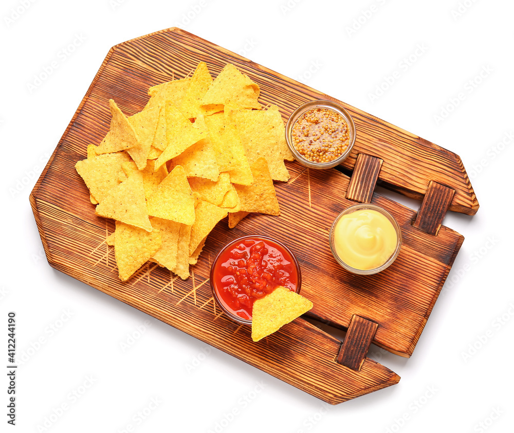 Board with tasty nachos and sauces on white background