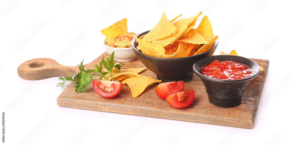 Board with tasty nachos and sauces on white background