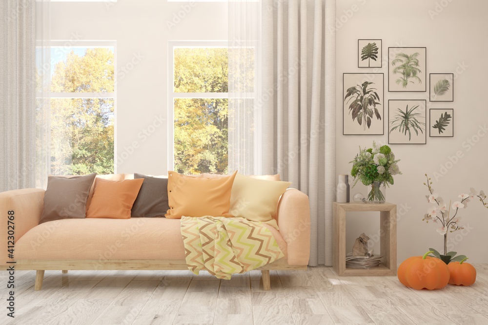 Stylish room in white color with sofa and autumn landscape in window. Scandinavian interior design. 