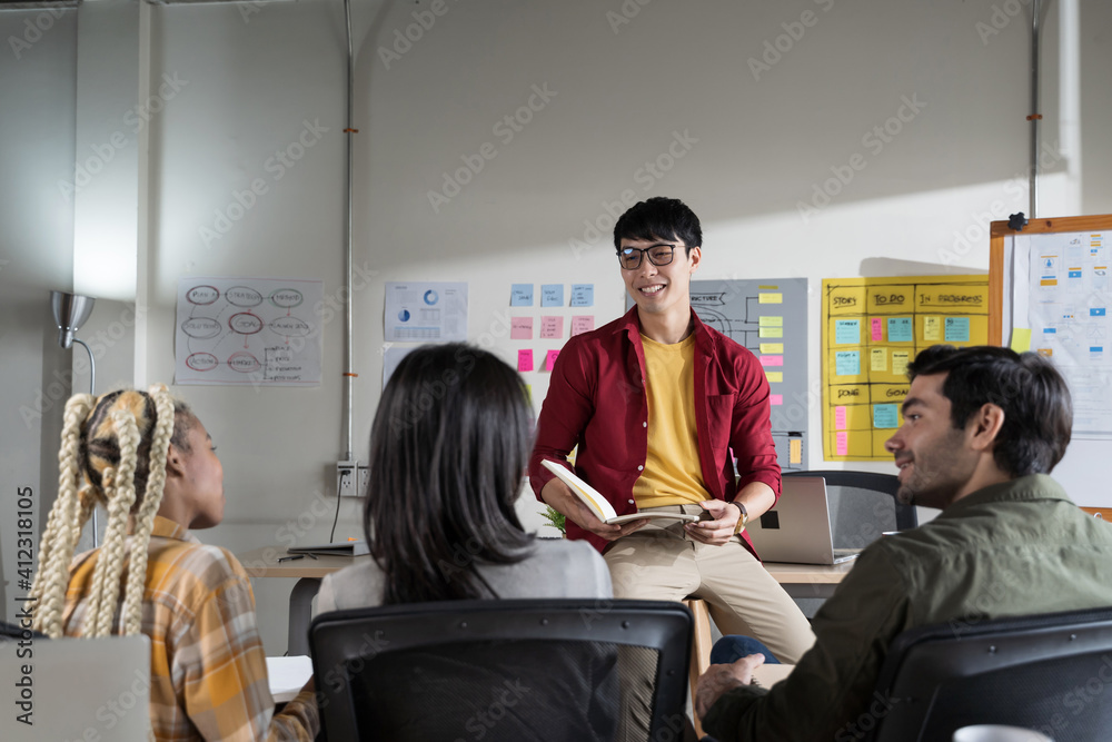 Asian young man creative designers present their work to the team. Designers are meeting in a modern