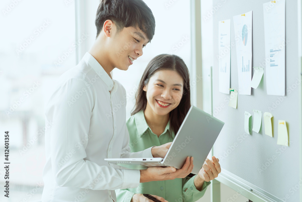 Young Asian business couple working together, completing the assigned work