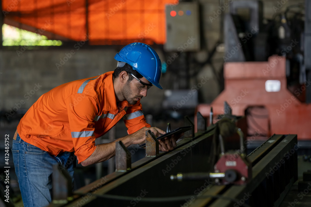 Engineer or factory worker using digital tablet checking inspecting metal component at machine in fa