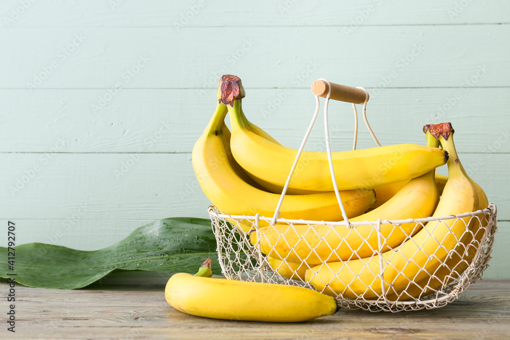 Basket with tasty bananas on wooden background