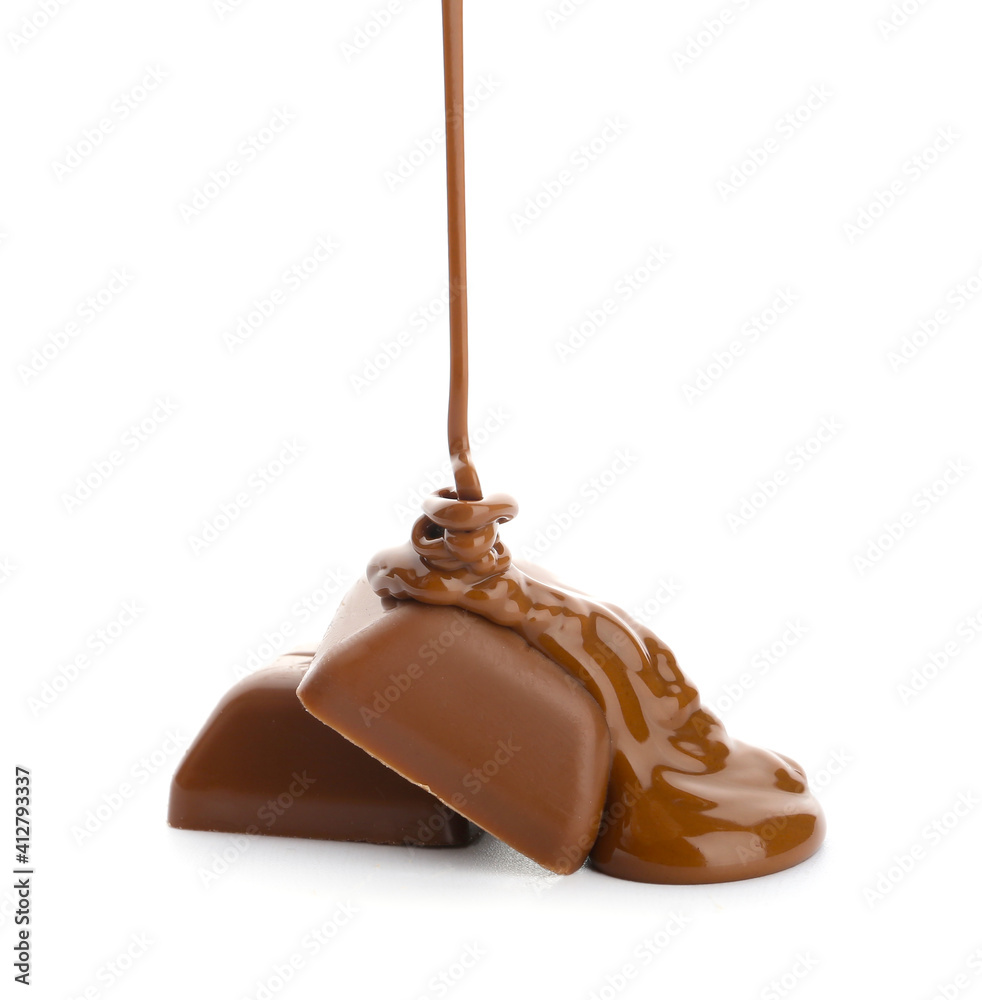 Pouring of melted chocolate on candy against white background