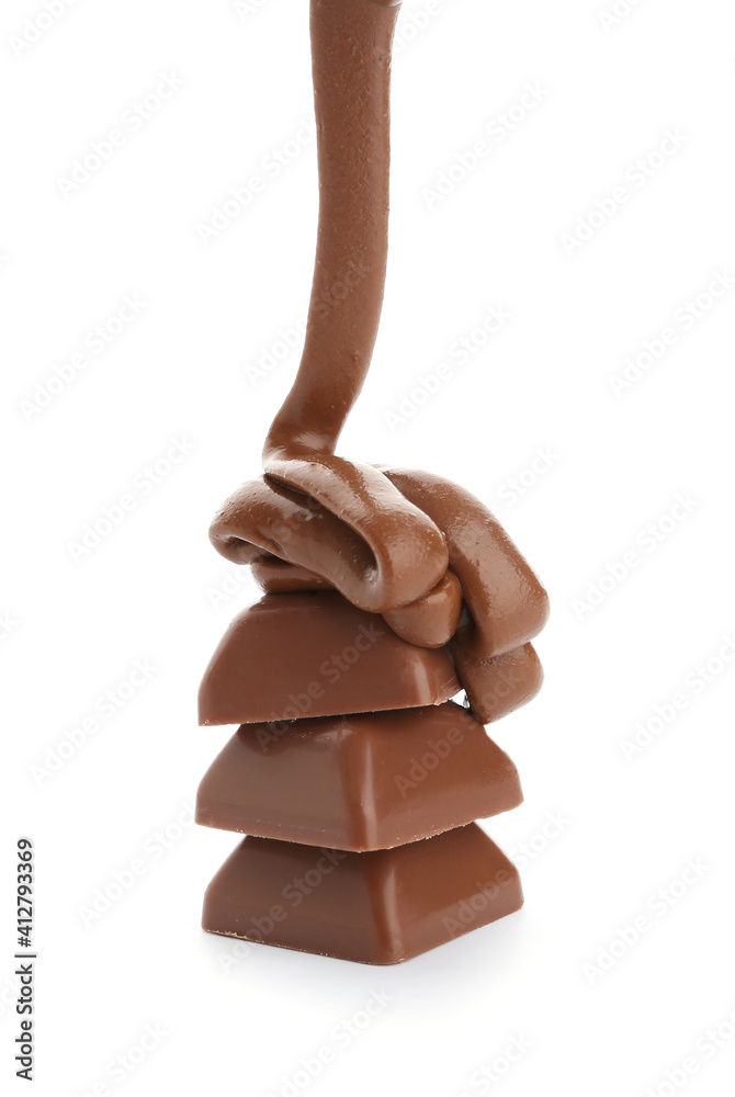 Pouring of melted chocolate on candies against white background