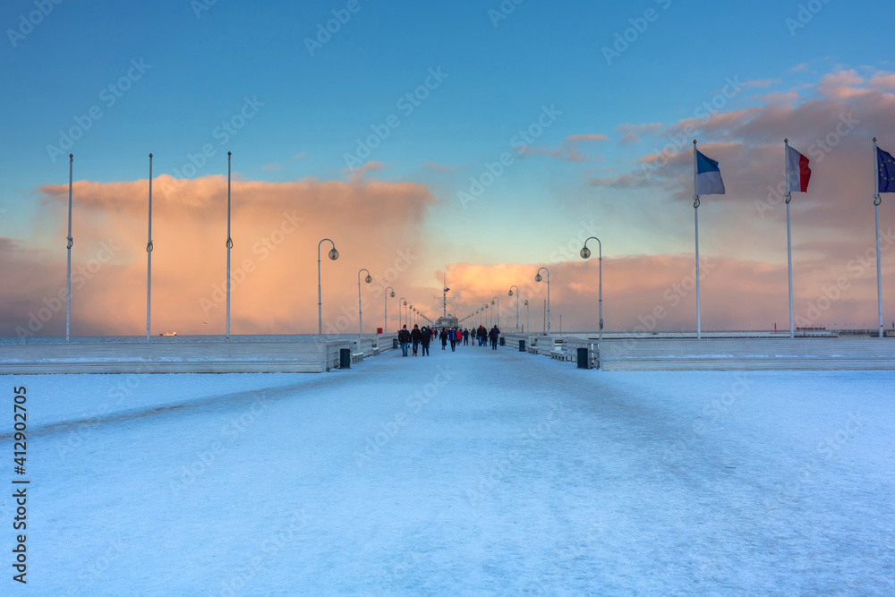 Beautiful sunset over the snowy pier (Molo) in Sopot at winter. Poland