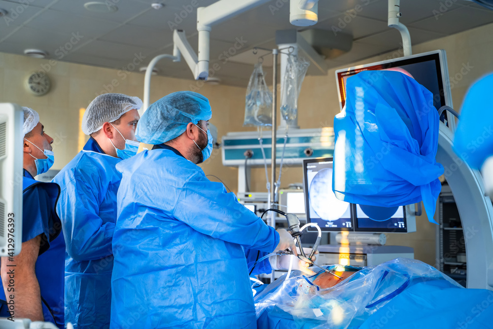 Surgeons working in operating room. Hospital background. Male doctors at work. Background of an oper