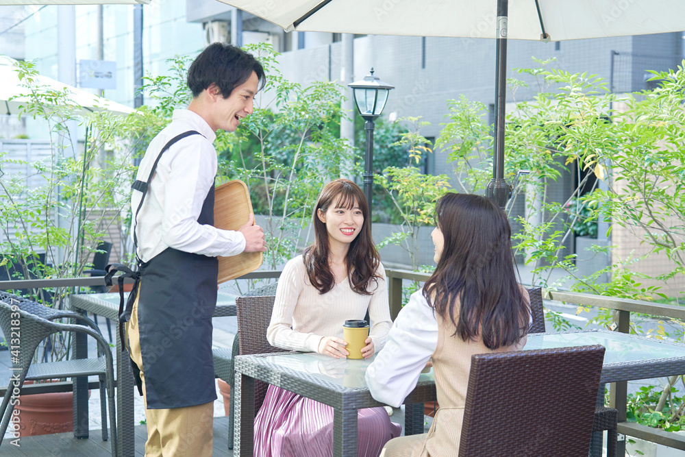 カフェテラスで話をする女性