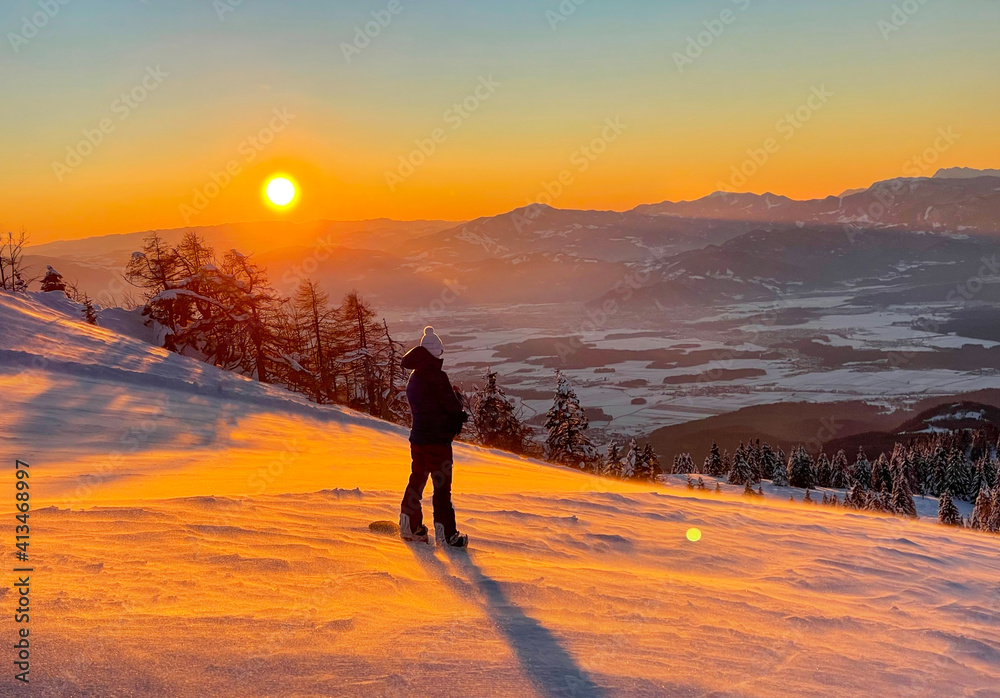 镜头闪光：女单板滑雪运动员在下降前观察金色的山谷