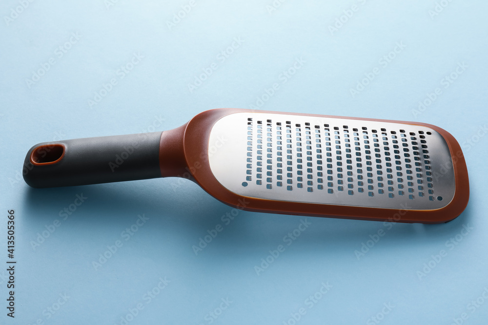 Metal grater on color background