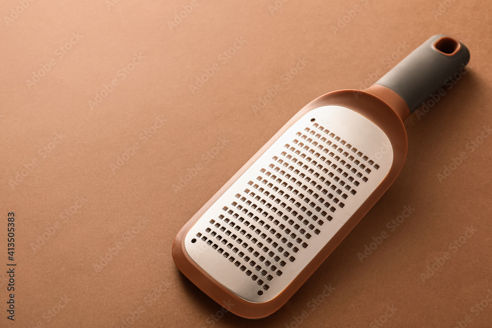 Metal grater on color background