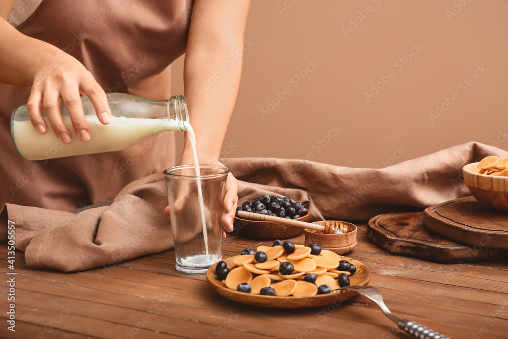 有美味煎饼、新鲜蓝莓和牛奶的女人