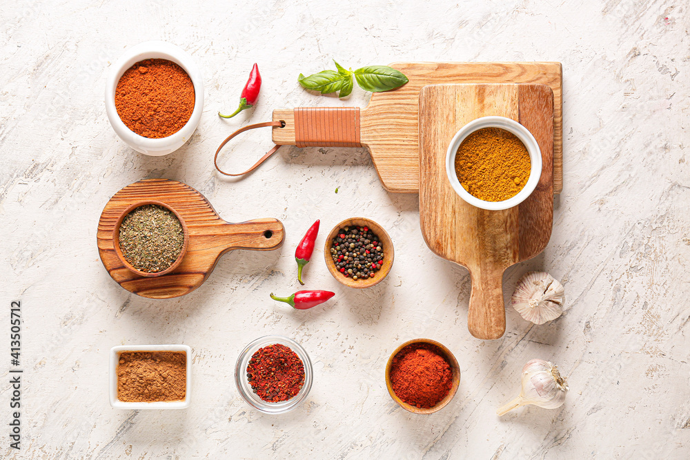 Bowls with different spices on light background