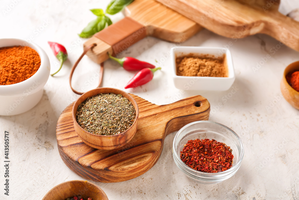 Bowls with different spices on light background