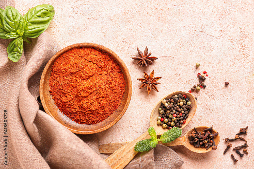 Bowl and spoons with different spices on color background