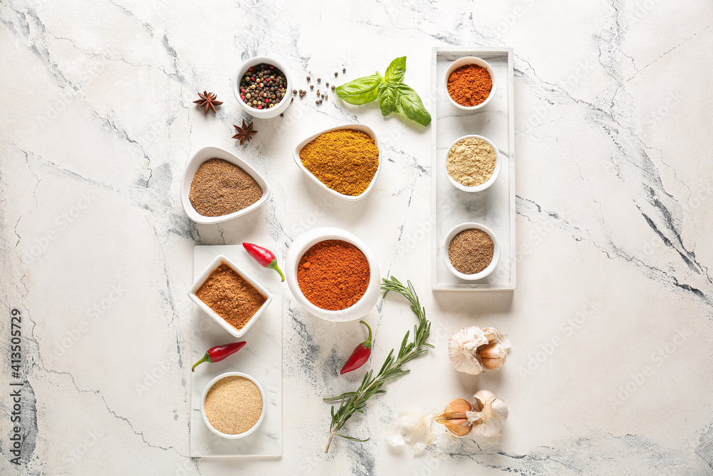 Bowls with different spices on light background