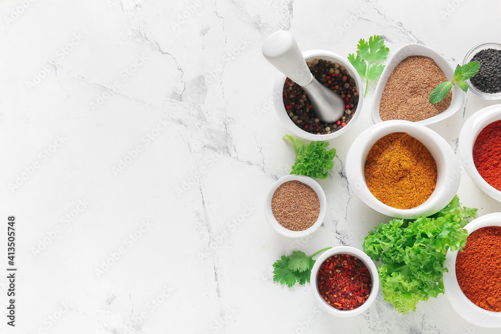 Bowls with different spices on light background