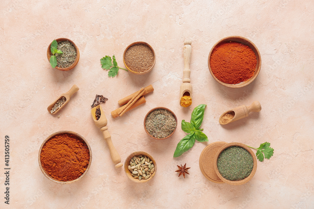 Bowls and scoops with different spices on color background