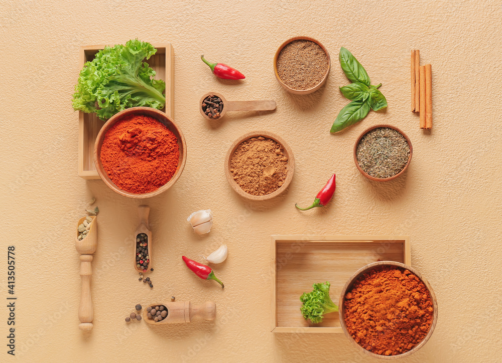 Bowls and scoops with different spices on color background