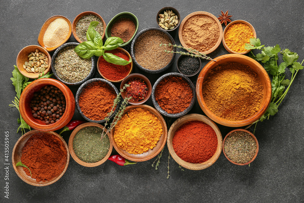 Bowls with different spices on dark background